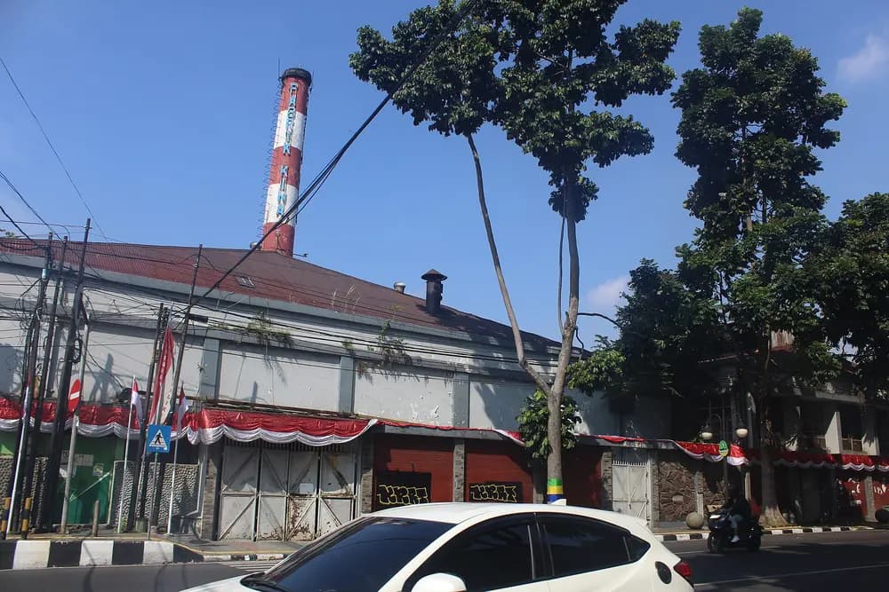 Cerobong asap pabrik menjulang di atas atap bangunan