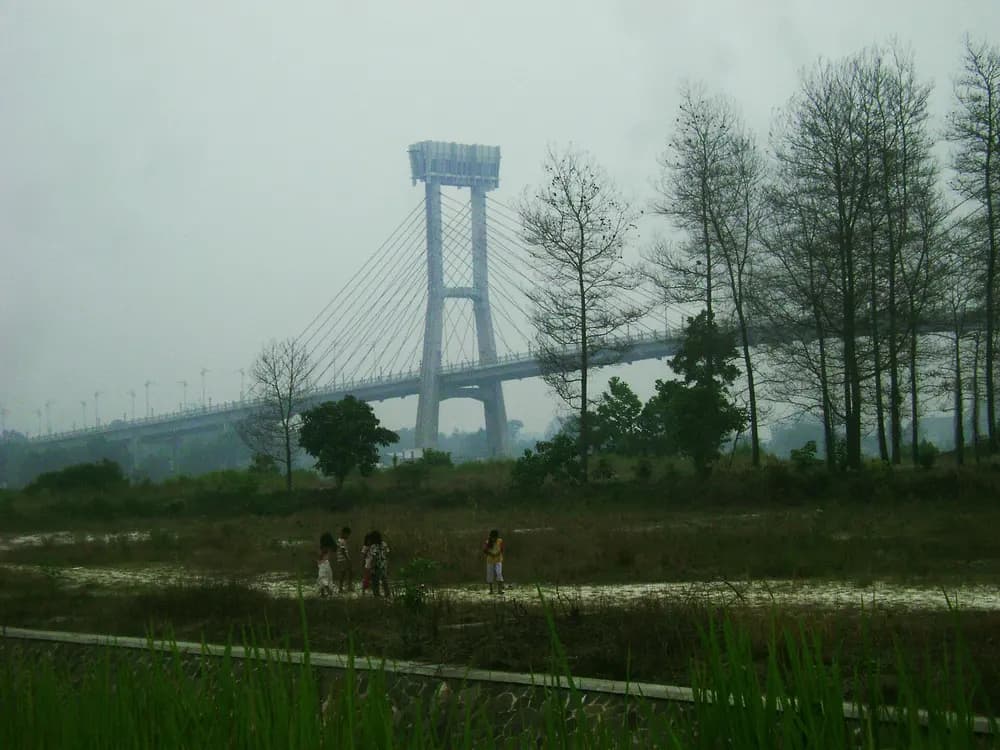 Anak-anak berjalan di tengah kabut asap dekat jembatan di Siak, Riau