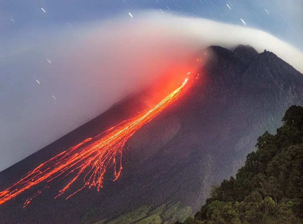 Guguran lava pijar menuruni lereng Merapi pada malam hari